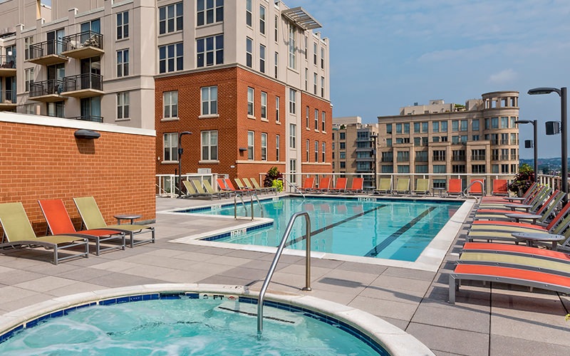 pool and hot tub with view of apartment building